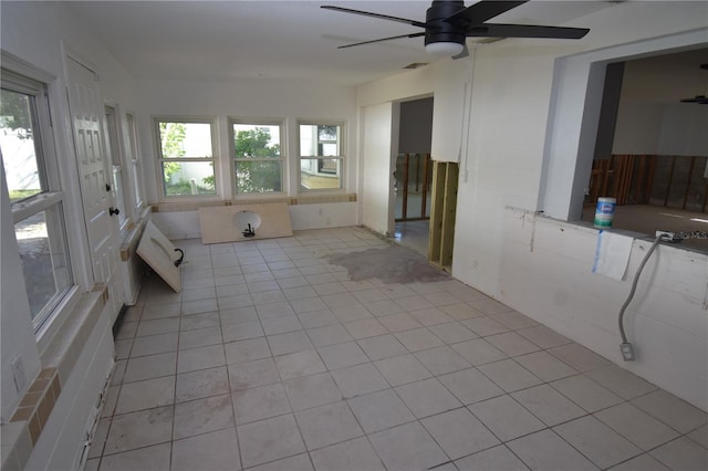 unfurnished sunroom with ceiling fan