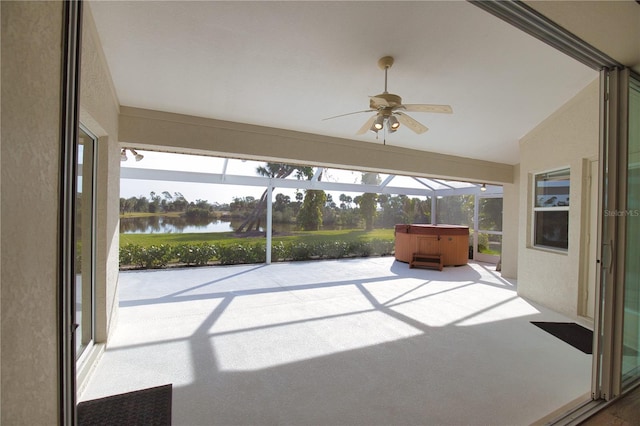 unfurnished sunroom with lofted ceiling, a wealth of natural light, ceiling fan, and a water view