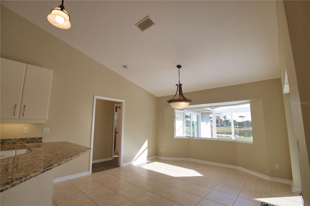 unfurnished dining area with light tile patterned flooring and high vaulted ceiling