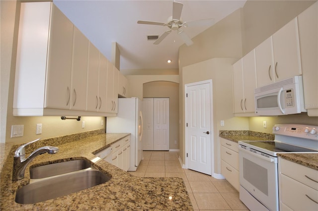 kitchen with sink, white appliances, white cabinets, and stone counters