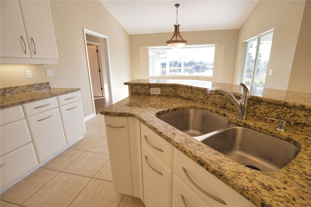 kitchen with sink, plenty of natural light, white cabinets, stone countertops, and vaulted ceiling