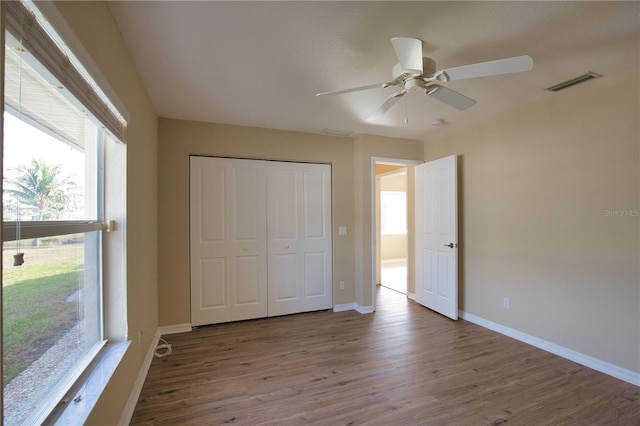 unfurnished bedroom with ceiling fan, wood-type flooring, and a closet