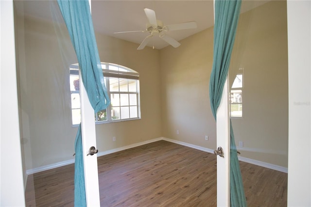 spare room featuring dark hardwood / wood-style flooring, french doors, and ceiling fan