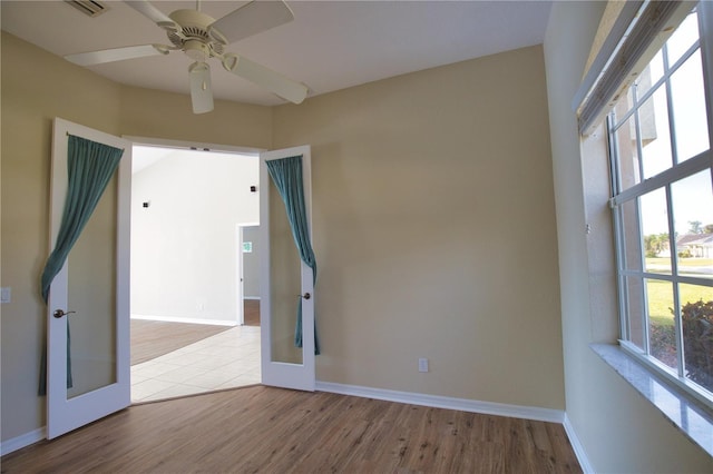 spare room featuring french doors, ceiling fan, and light hardwood / wood-style flooring