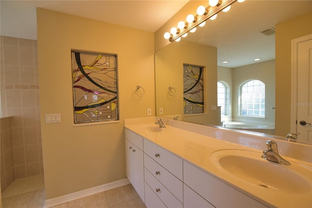 bathroom with tile patterned flooring, a bathing tub, and vanity