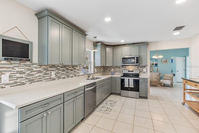 kitchen featuring gray cabinets, appliances with stainless steel finishes, sink, and pendant lighting