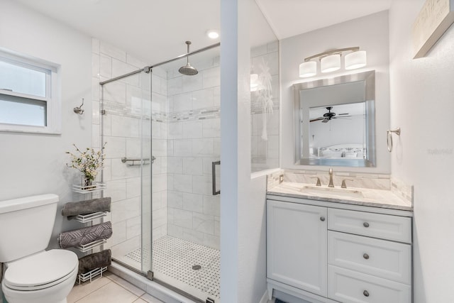 bathroom featuring walk in shower, vanity, toilet, and tile patterned flooring