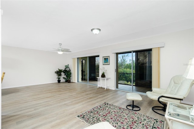 living room with ceiling fan and light wood-type flooring