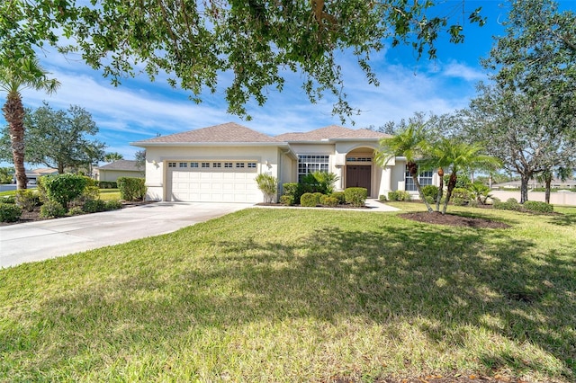 view of front of house with concrete driveway, a garage, a front yard, and stucco siding