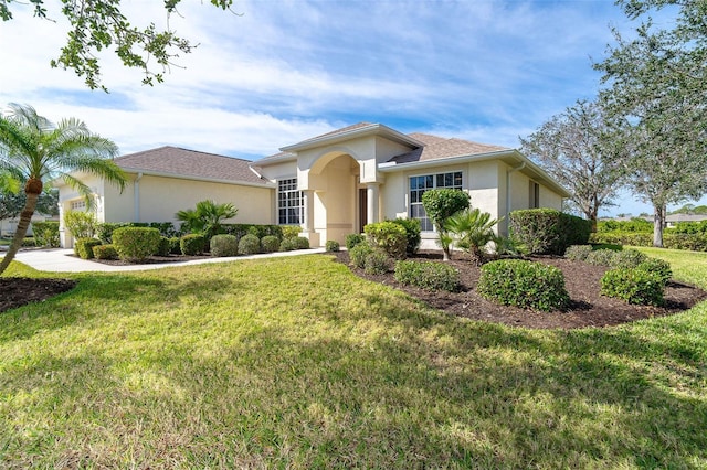 view of front facade with stucco siding, an attached garage, and a front lawn