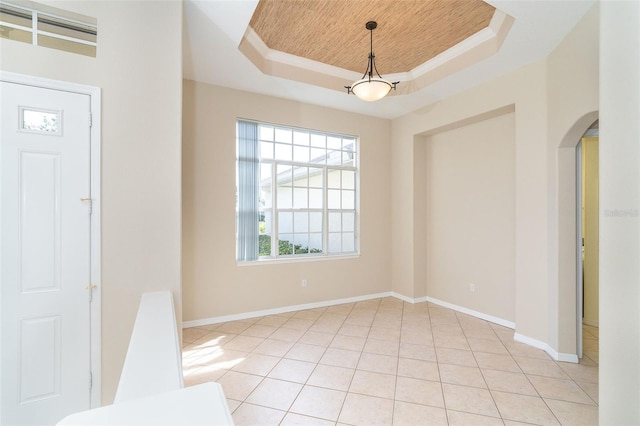 entryway featuring a raised ceiling, ornamental molding, light tile patterned floors, and wooden ceiling