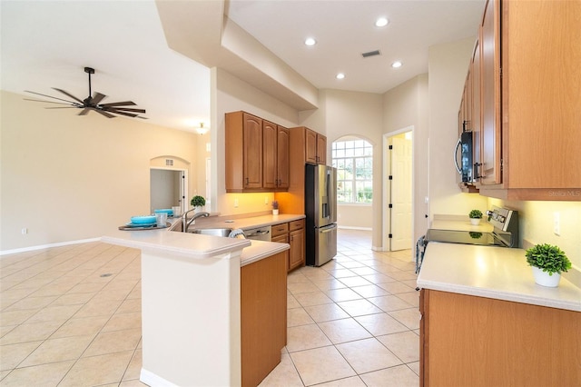 kitchen with ceiling fan, appliances with stainless steel finishes, kitchen peninsula, and light tile patterned floors