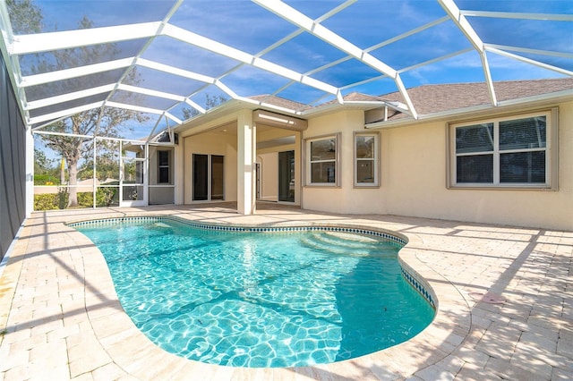 view of pool with a patio and glass enclosure