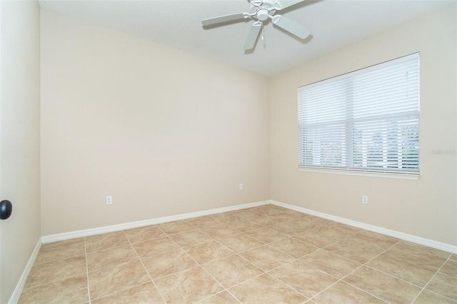 spare room featuring light tile patterned flooring, ceiling fan, and baseboards