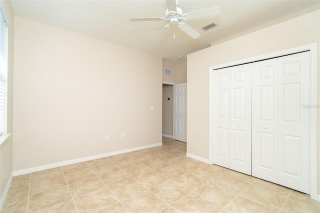 unfurnished bedroom featuring light tile patterned floors, ceiling fan, and a closet