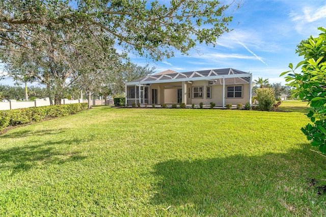 view of front of home featuring stucco siding, a lanai, a front yard, and fence