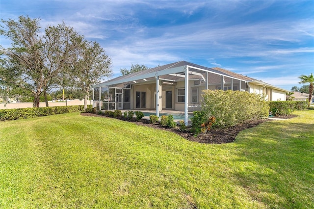 view of side of property with glass enclosure, a patio, and a yard