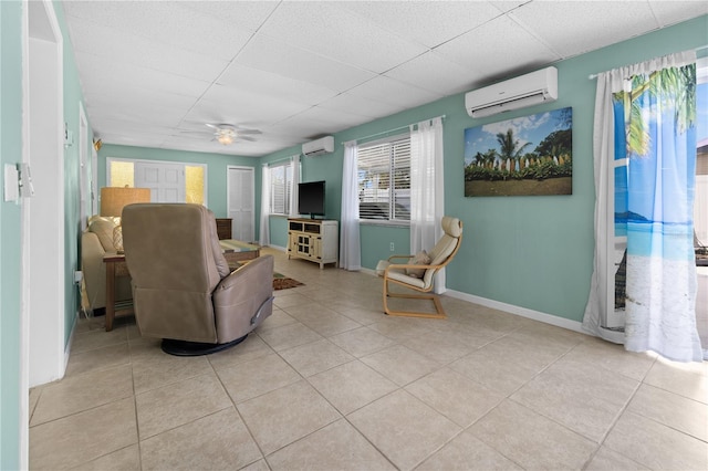 539 Shore Rd, Nokomis, FL 34275 - living room with a wall unit AC, a paneled ceiling, tile patterned flooring, and ceiling fan