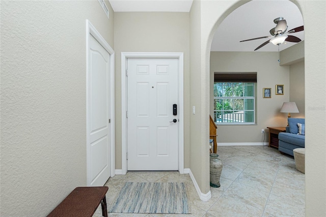 foyer entrance featuring light tile patterned floors and ceiling fan