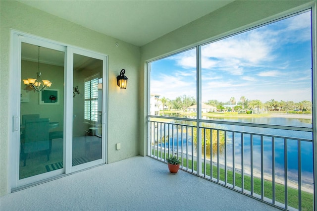 sunroom featuring an inviting chandelier, a wealth of natural light, and a water view