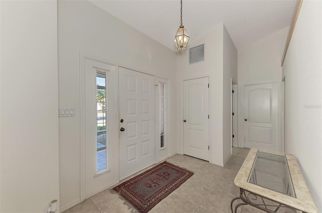 tiled foyer entrance featuring high vaulted ceiling