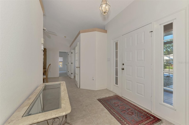 foyer entrance with light tile patterned flooring, ceiling fan, and plenty of natural light