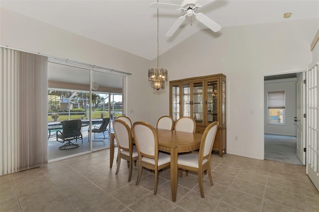 tiled dining space featuring lofted ceiling and ceiling fan with notable chandelier