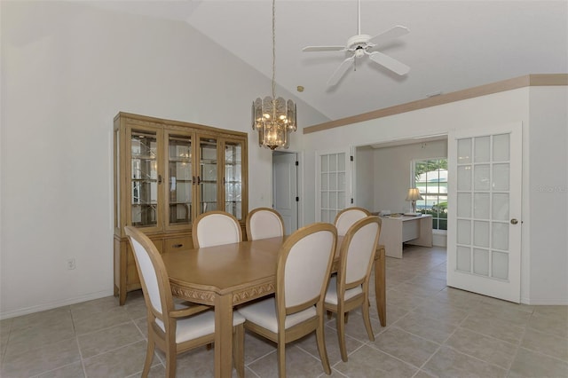 tiled dining space featuring ceiling fan with notable chandelier and high vaulted ceiling