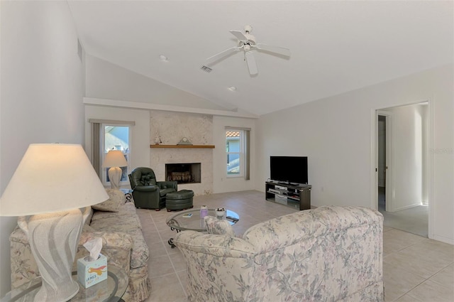 tiled living room featuring lofted ceiling, a large fireplace, and ceiling fan