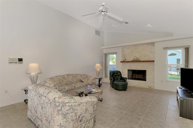 tiled living room with ceiling fan, a high end fireplace, and vaulted ceiling