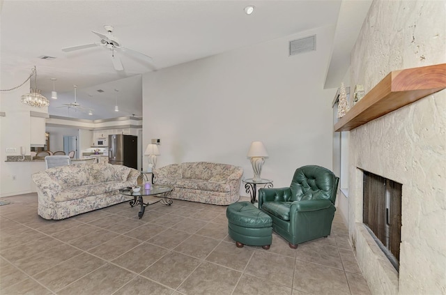 living room featuring lofted ceiling, tile patterned floors, ceiling fan, and a fireplace