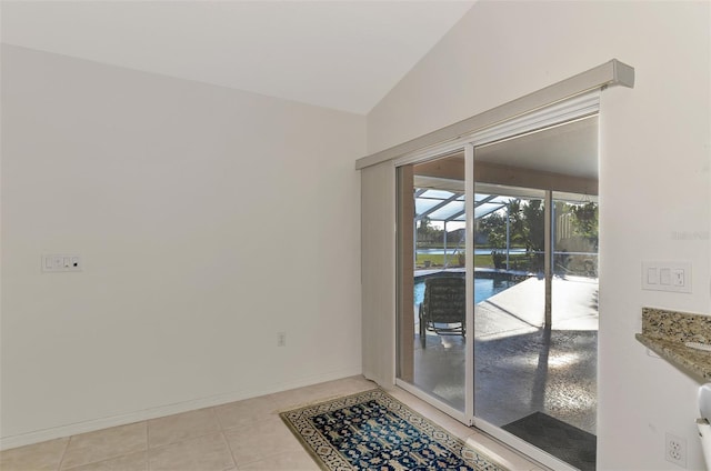 interior space with vaulted ceiling and light tile patterned floors