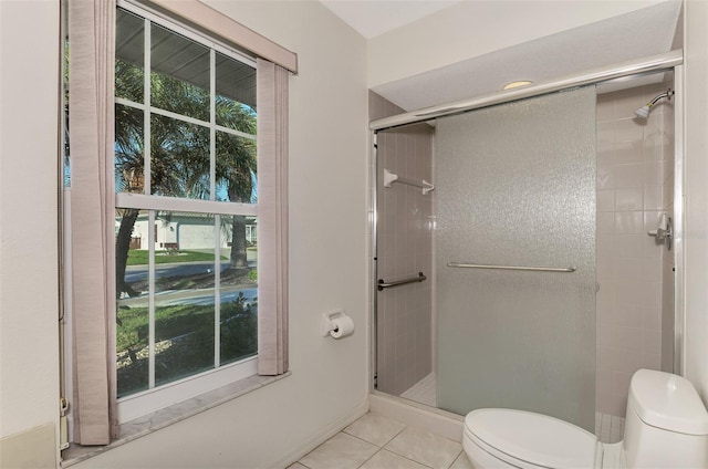 bathroom with a shower with shower door, tile patterned floors, and toilet