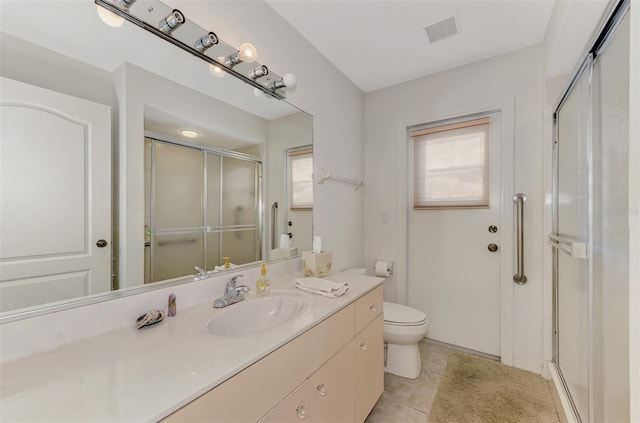 bathroom featuring vanity, tile patterned floors, toilet, and walk in shower