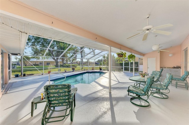 view of swimming pool featuring a patio area, ceiling fan, and glass enclosure