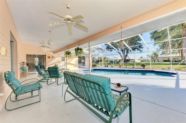 view of swimming pool with a patio area, ceiling fan, and glass enclosure