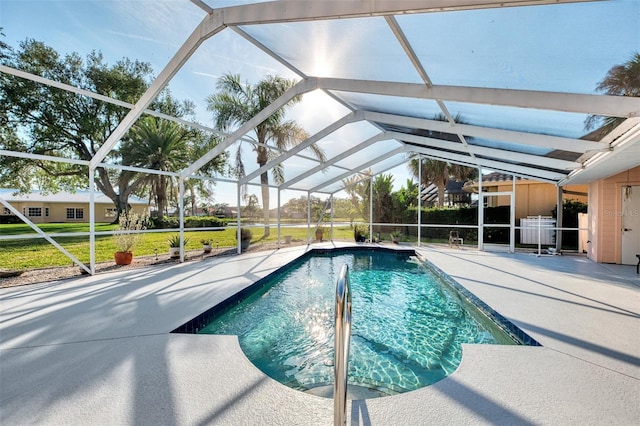 view of swimming pool with a patio, a yard, and glass enclosure