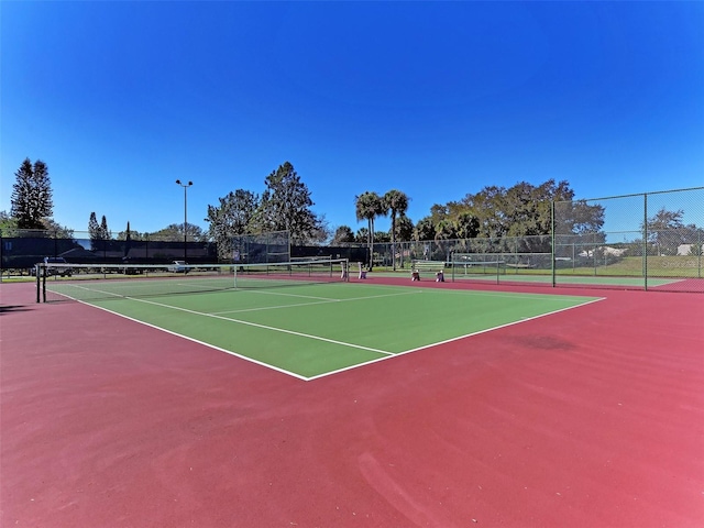 view of tennis court with basketball hoop