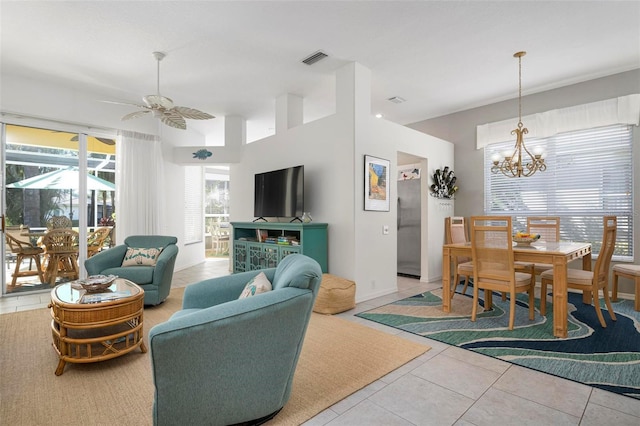 living room with ceiling fan with notable chandelier and tile patterned floors