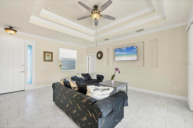 living room with a tray ceiling, ornamental molding, and ceiling fan