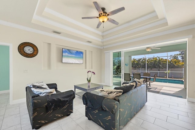 living room featuring crown molding, ceiling fan, and a tray ceiling