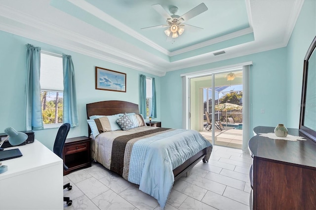 bedroom with multiple windows, a raised ceiling, ornamental molding, and access to exterior