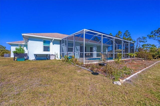 rear view of property with a yard, cooling unit, and glass enclosure