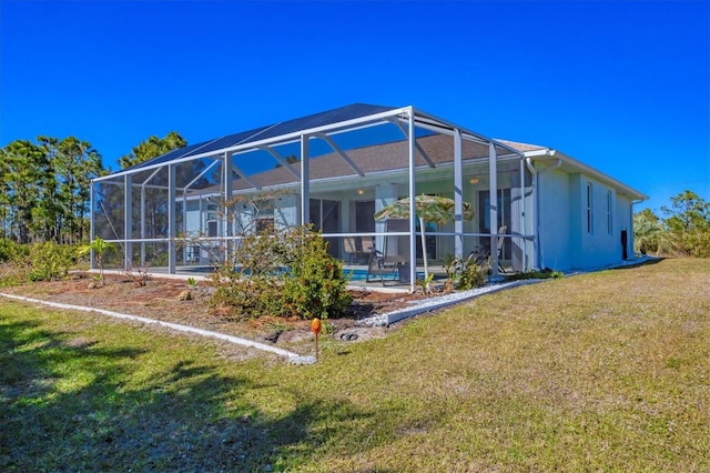 back of house featuring a pool, a lanai, and a yard