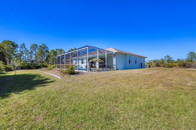 rear view of property featuring a lanai and a yard