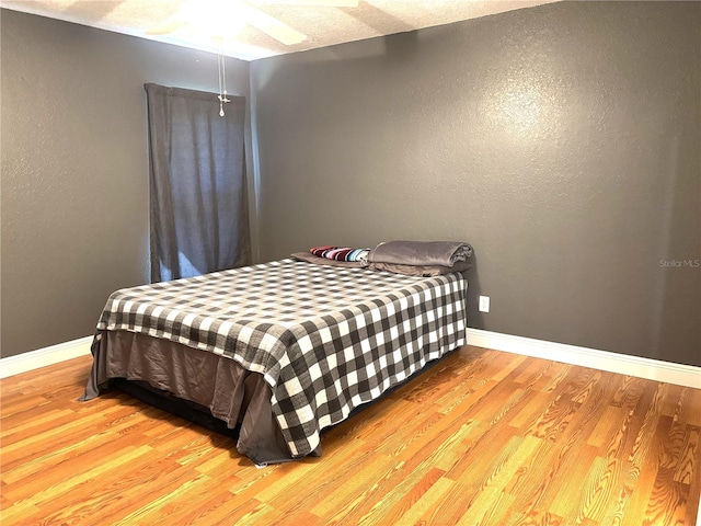 bedroom featuring ceiling fan and light hardwood / wood-style flooring