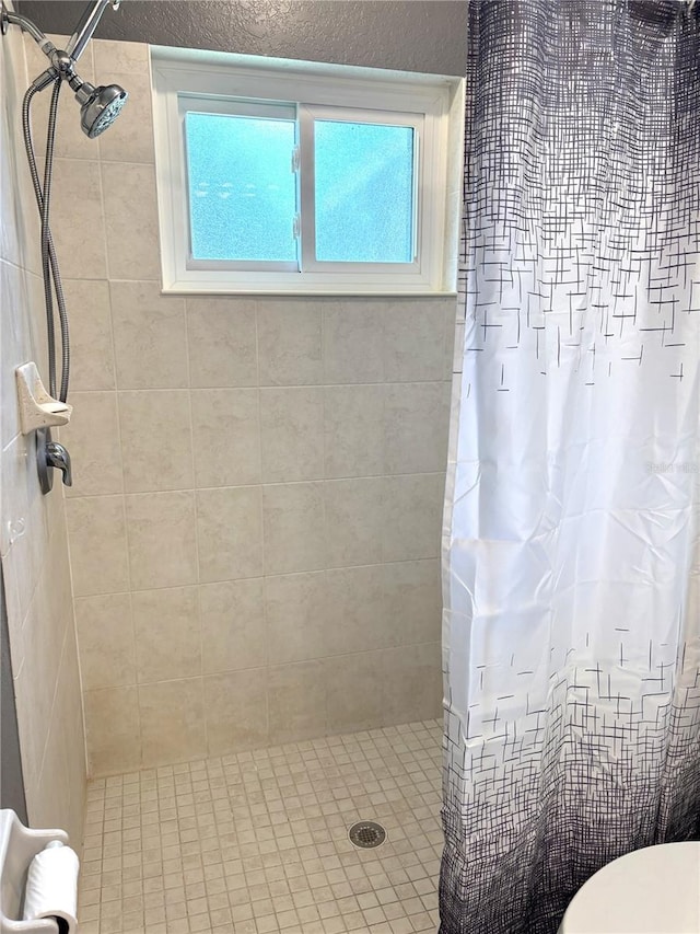 bathroom with curtained shower and toilet