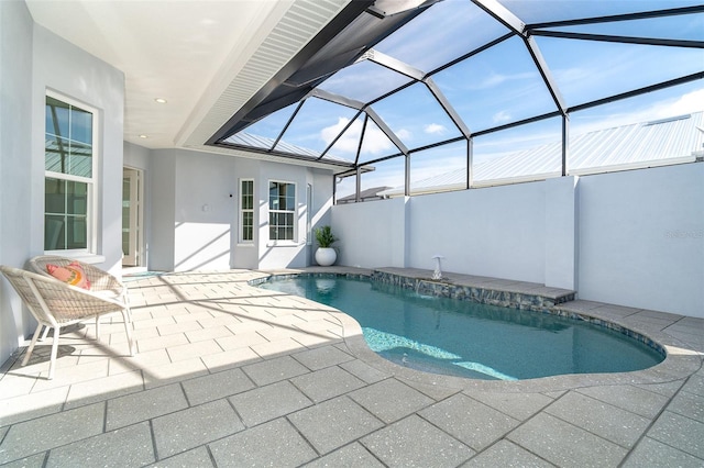 view of pool with a patio and glass enclosure