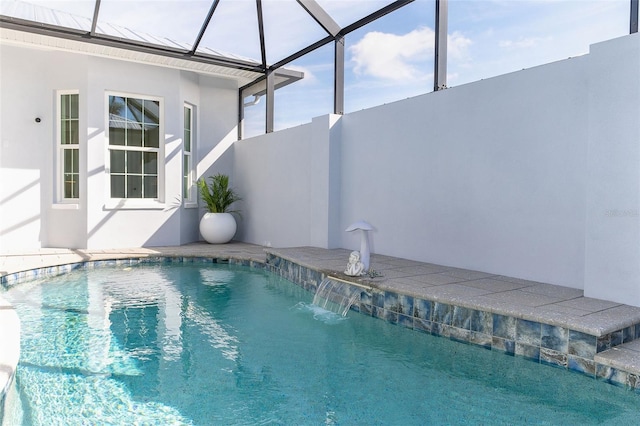 view of swimming pool featuring pool water feature and glass enclosure