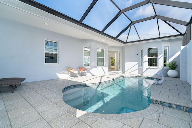 view of pool featuring glass enclosure and a patio area